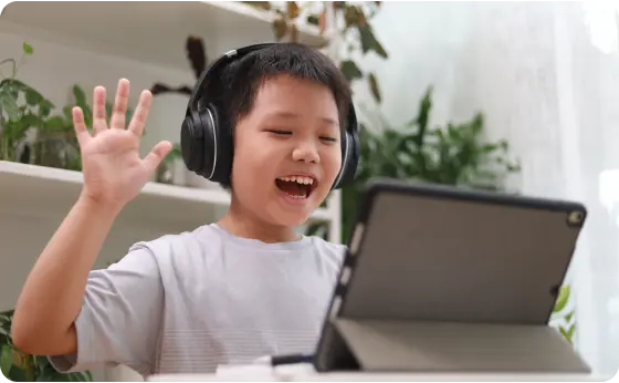 Elementary student attending to an online class wearing blck headphones