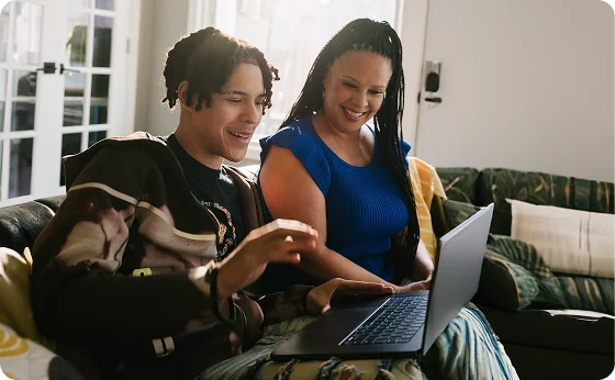 Student with his mom working with their laptop
